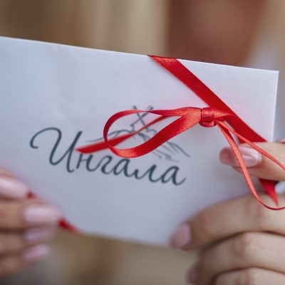 Image of young female holding valentine letter in hands